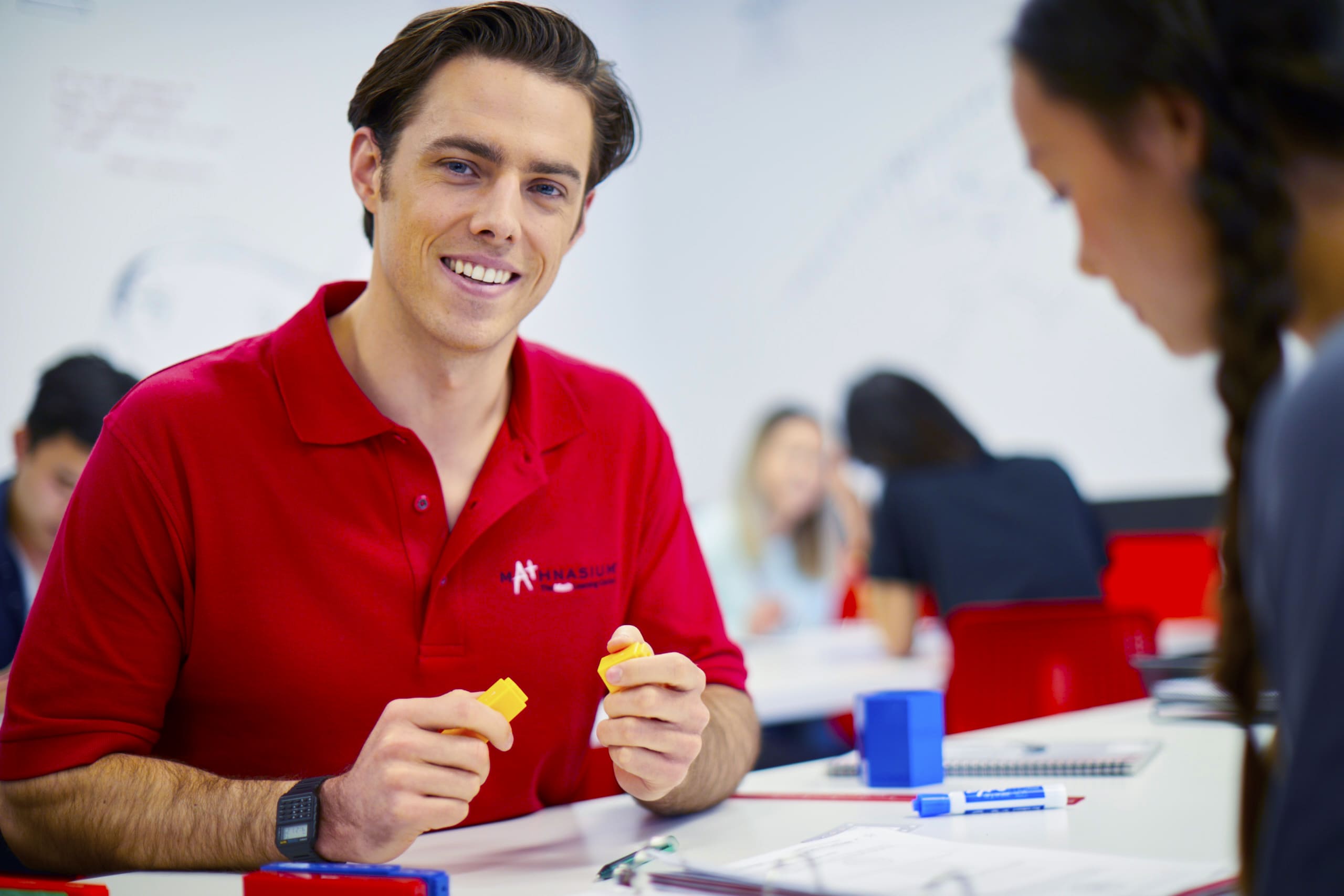 A Mathnasium tutor using math cubes to explain a math concept.
