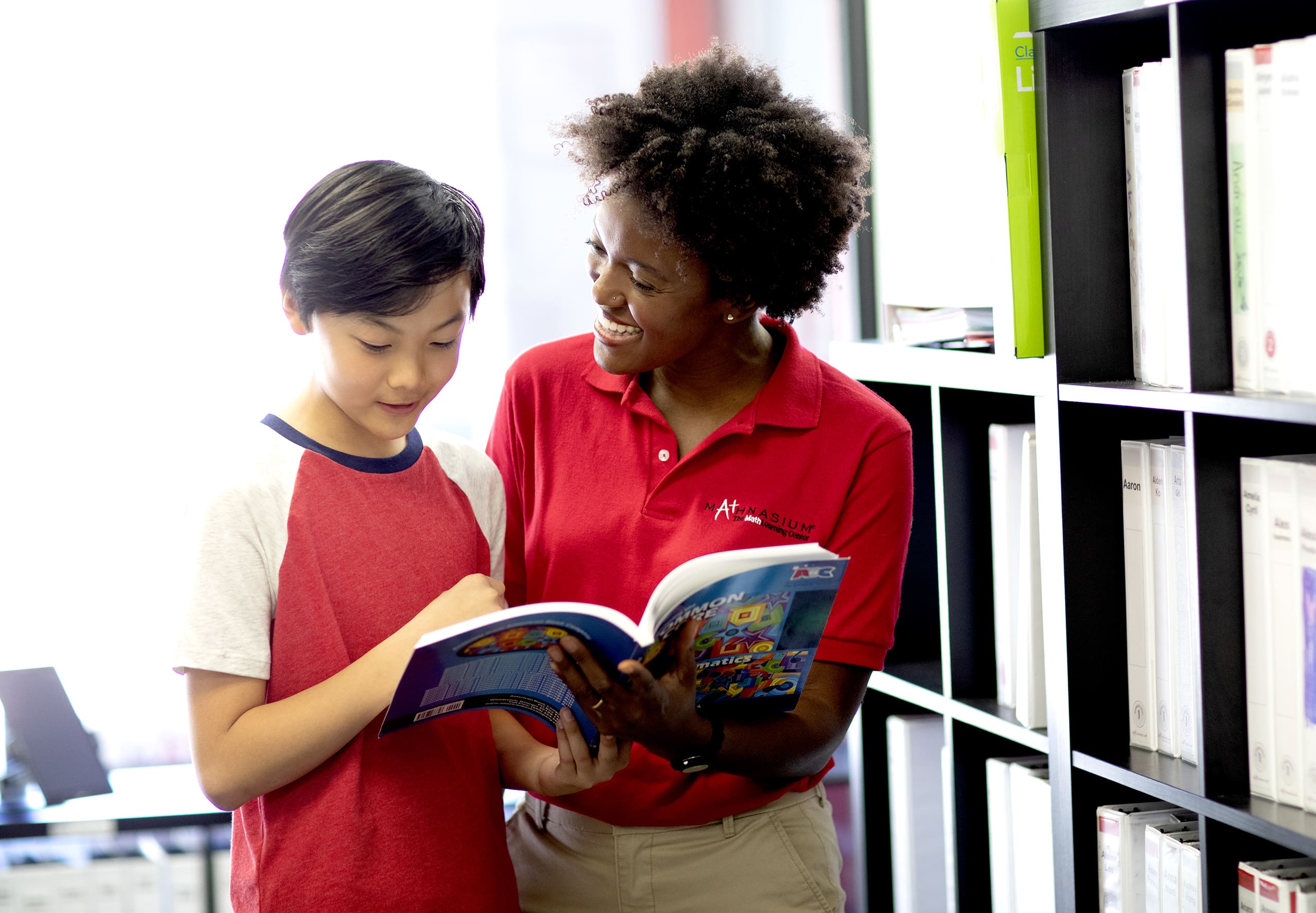 Student and math tutor looking at math textbook.