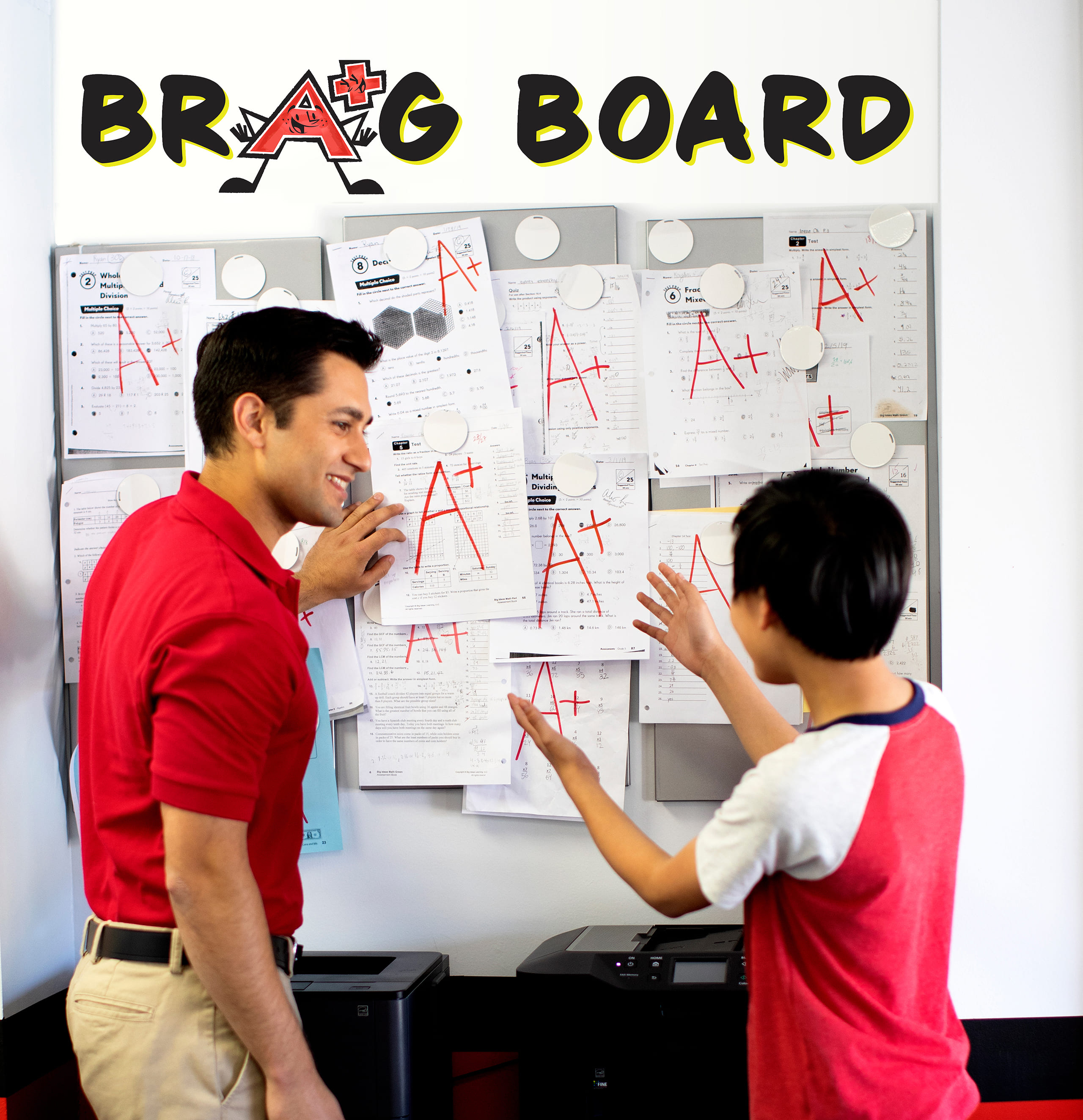 Student and math tutor next to a board with good test scores