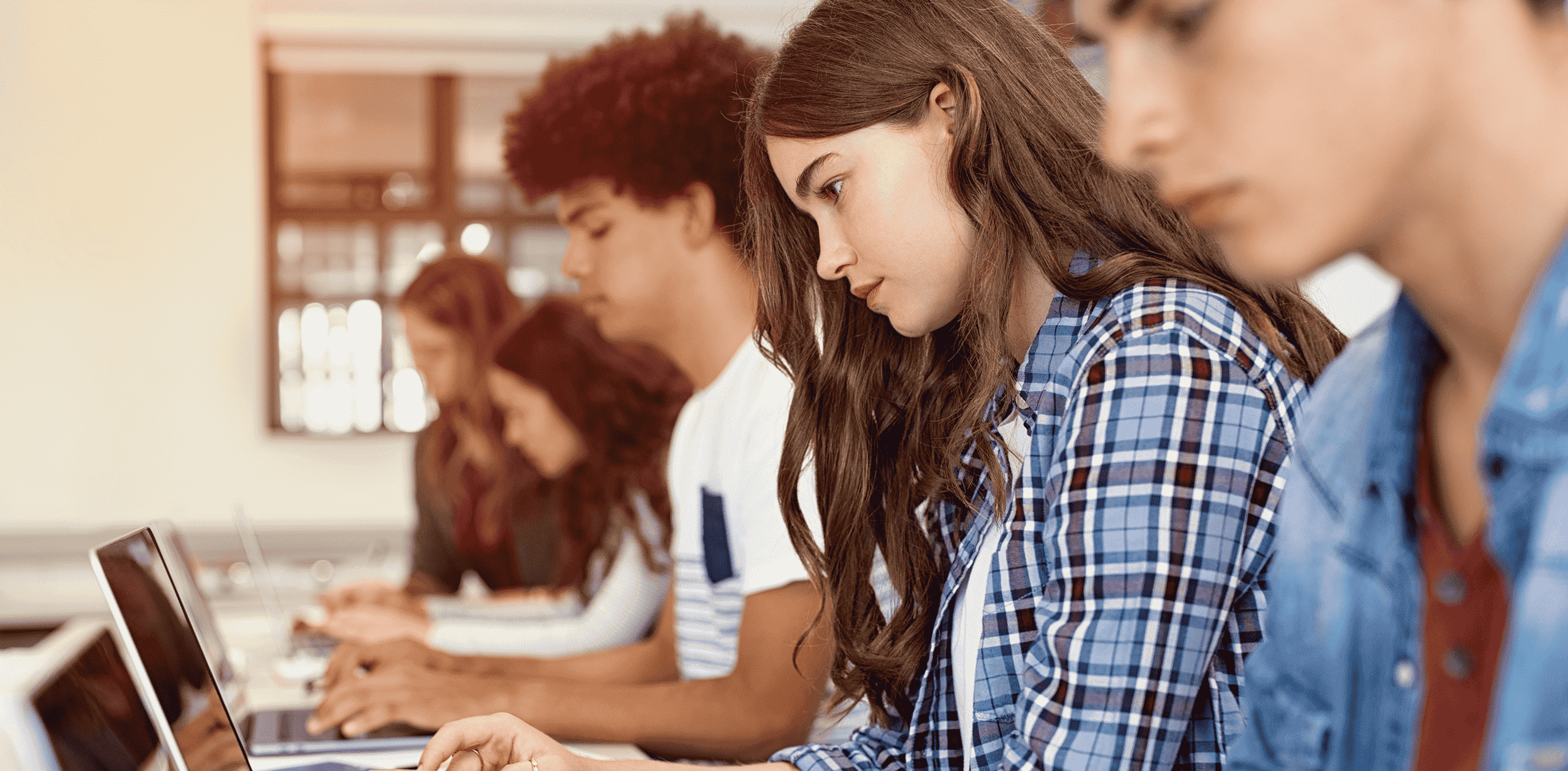 Students learning on laptops in a classroom