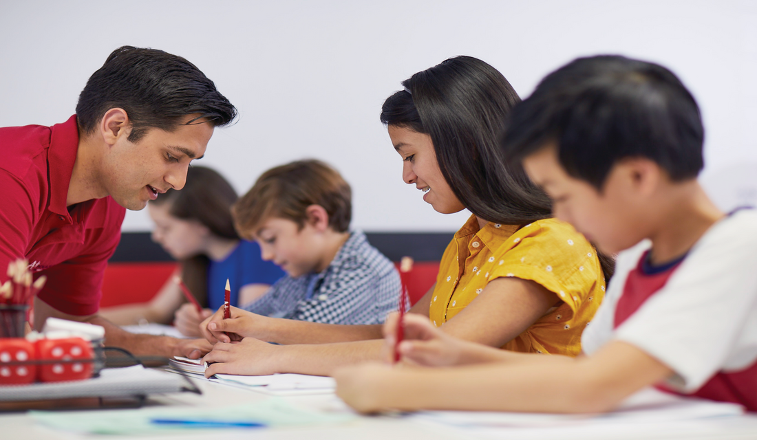 Mathnasium Tutor working with students at a table.